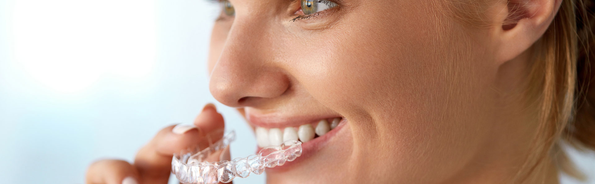 Beautiful woman smiling after invisalign treatments